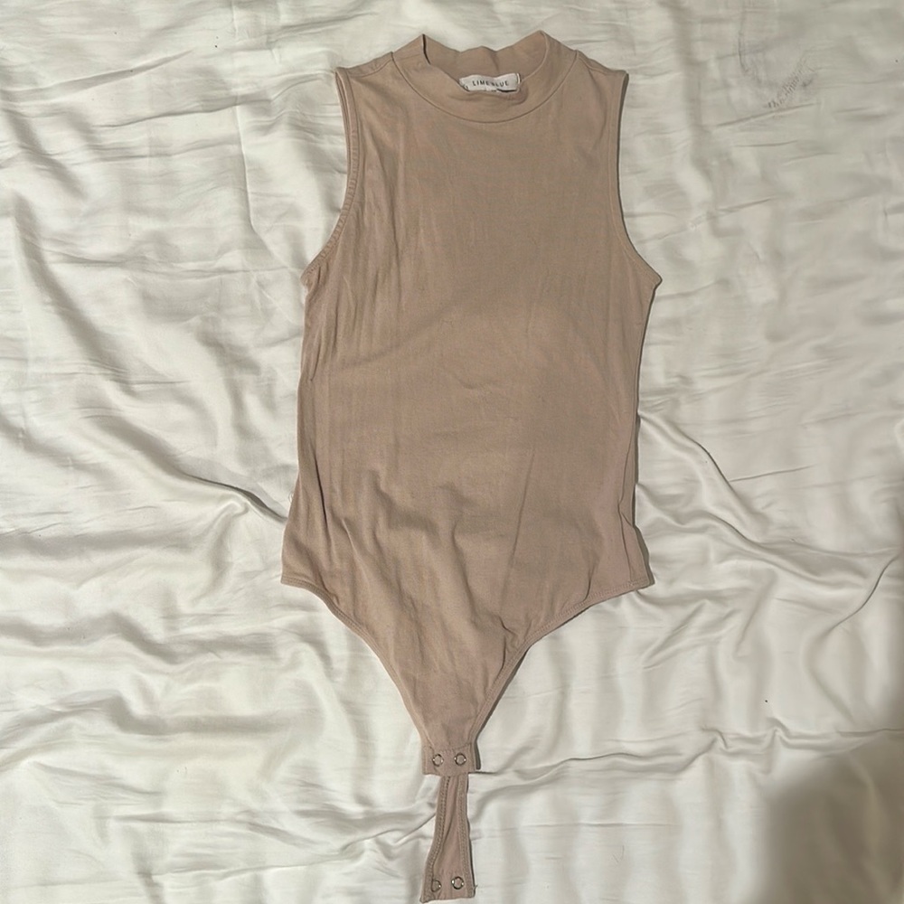 Sleeveless bodysuit thong in cream.